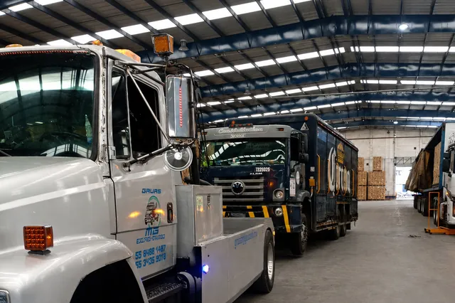 Unidades de Grúas MG dentro de una nave industrial junto a un camión de reparto