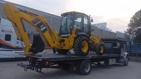 Grúa de plataforma de Grúas MG transportando una retroexcavadora en CDMX
